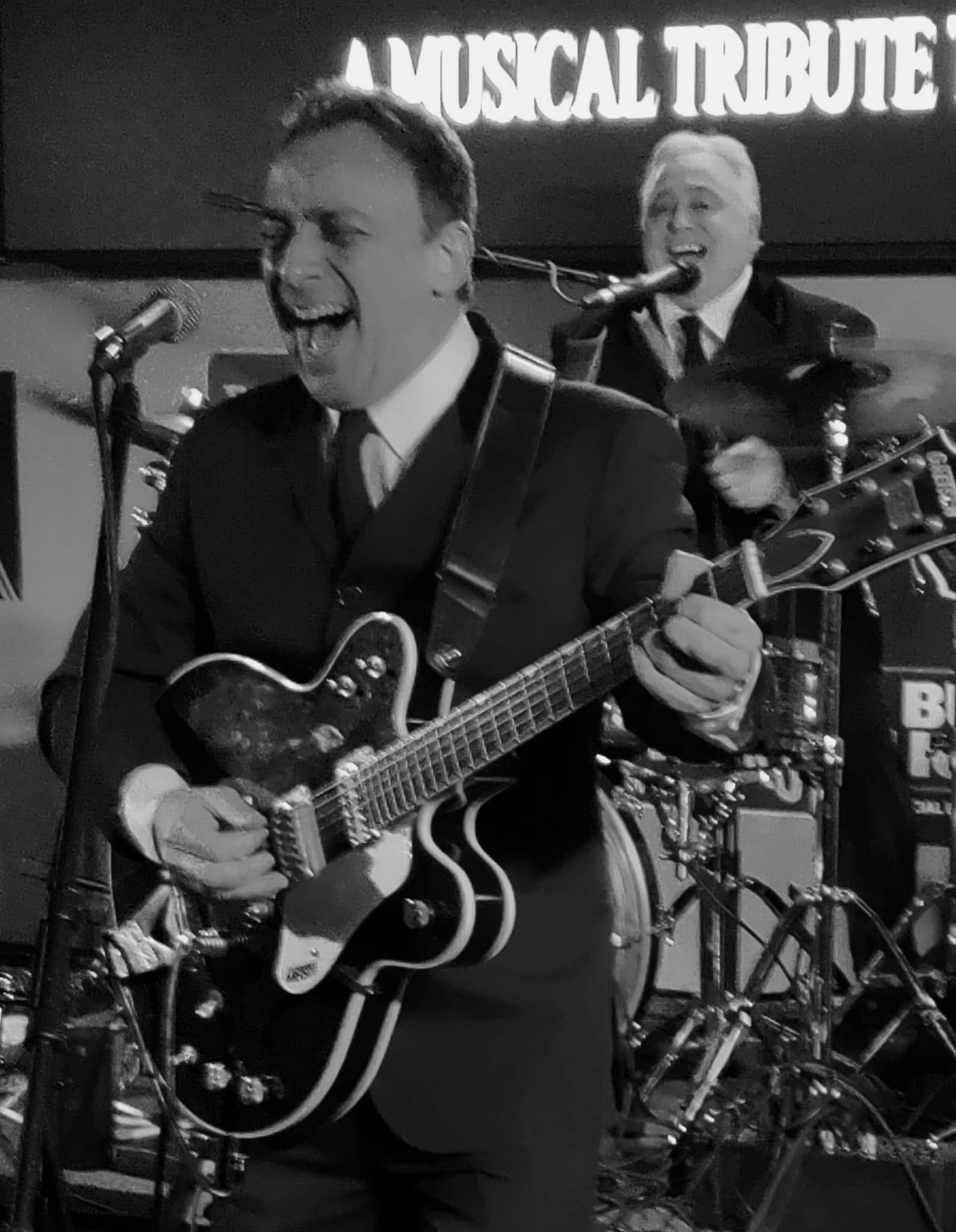 Boots & Suits guitarist singing into the mic